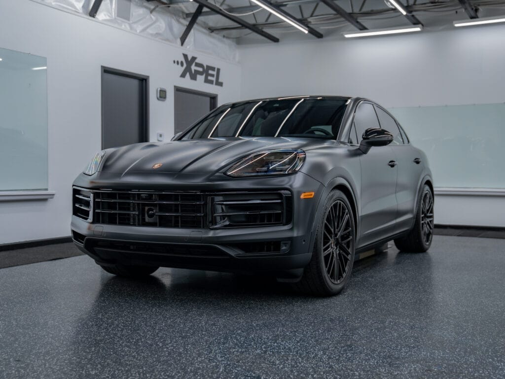 Luxury SUV with matte black finish parked indoors showing paint protection film.