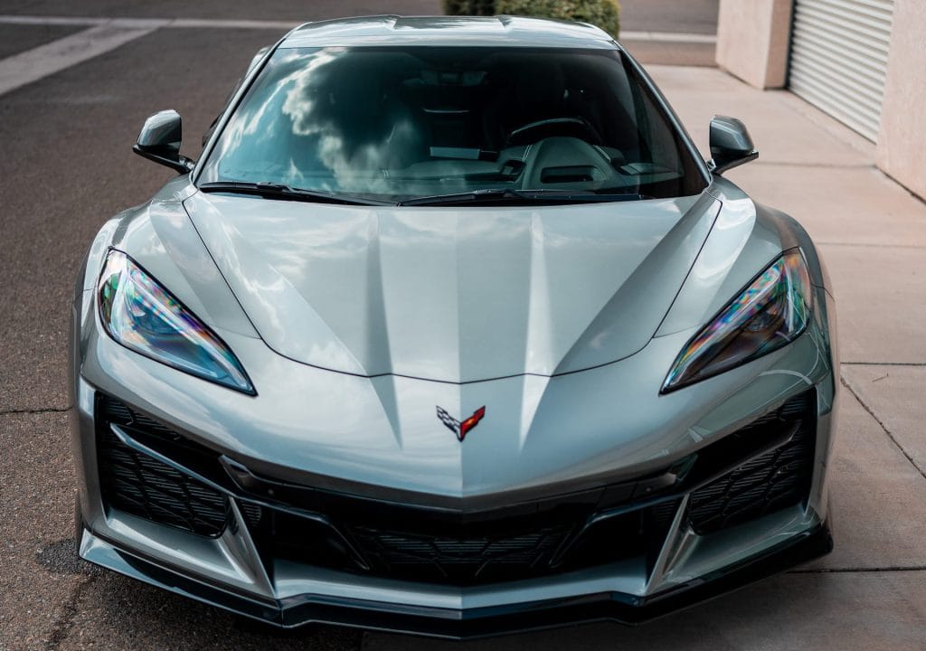 Silver sports car with tinted windows parked outdoors.